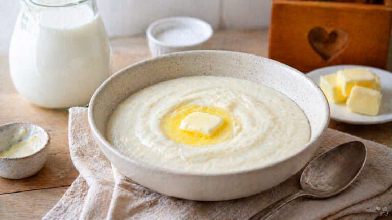 Готовая манная каша на молоке в тарелке с кусочком масла